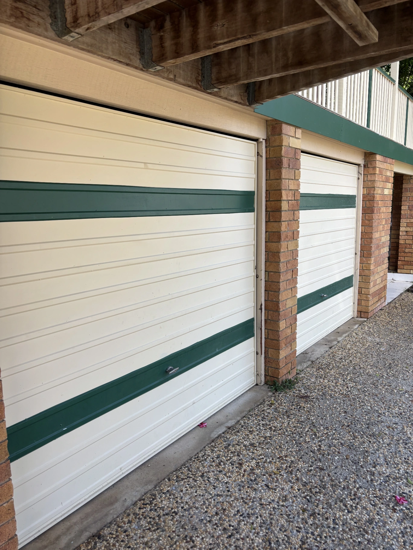 Cream garage doors with green bands before repainting