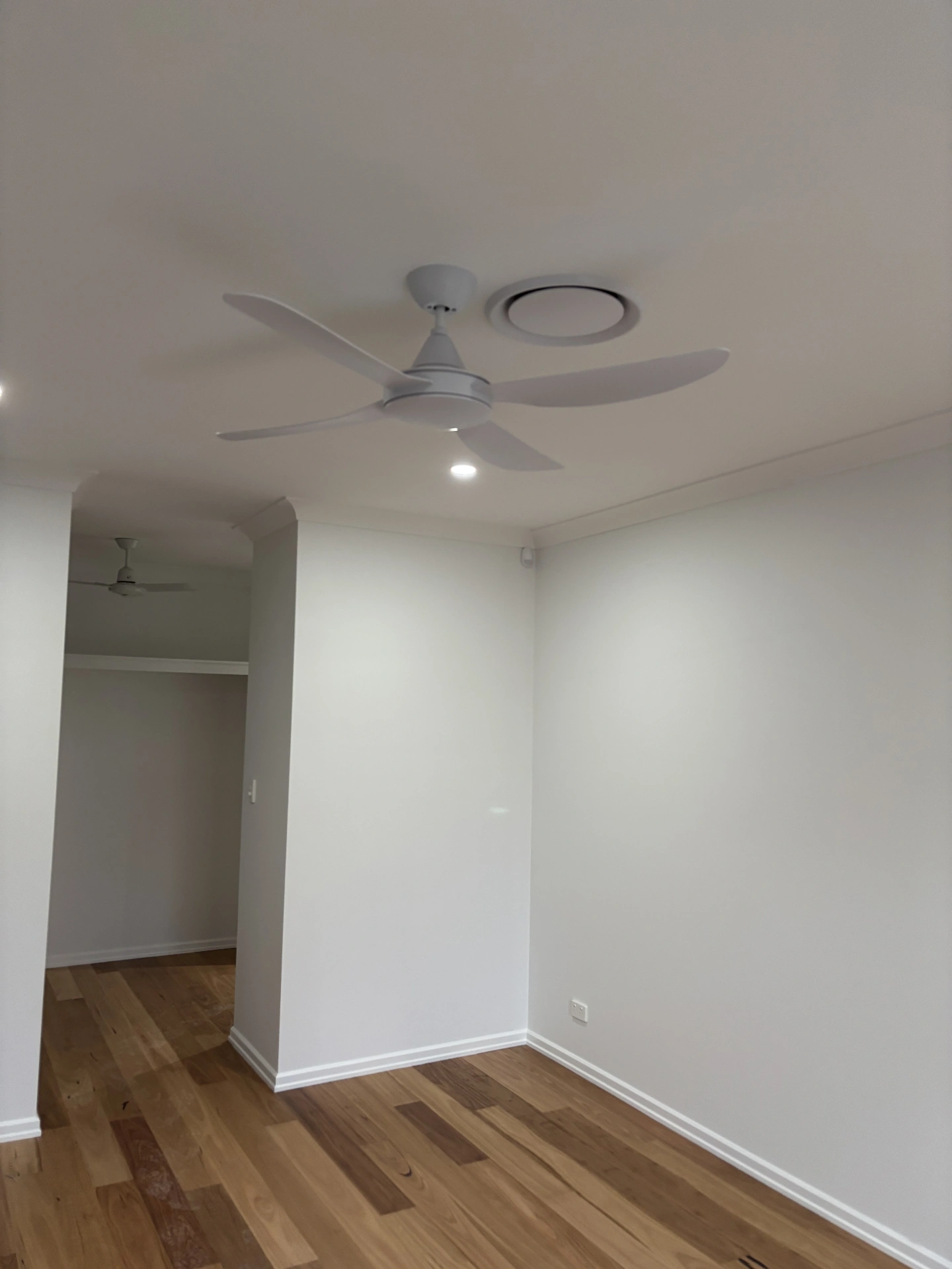 Fresh white interior with a ceiling fan and timber flooring