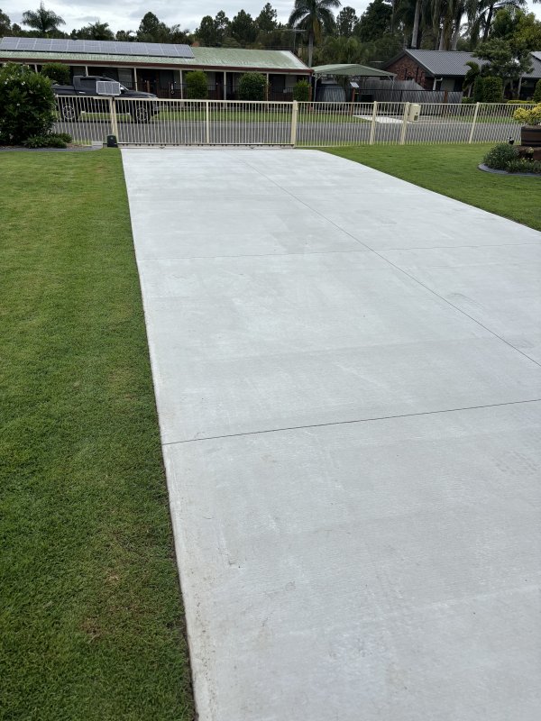 Freshly finished driveway beside a green lawn