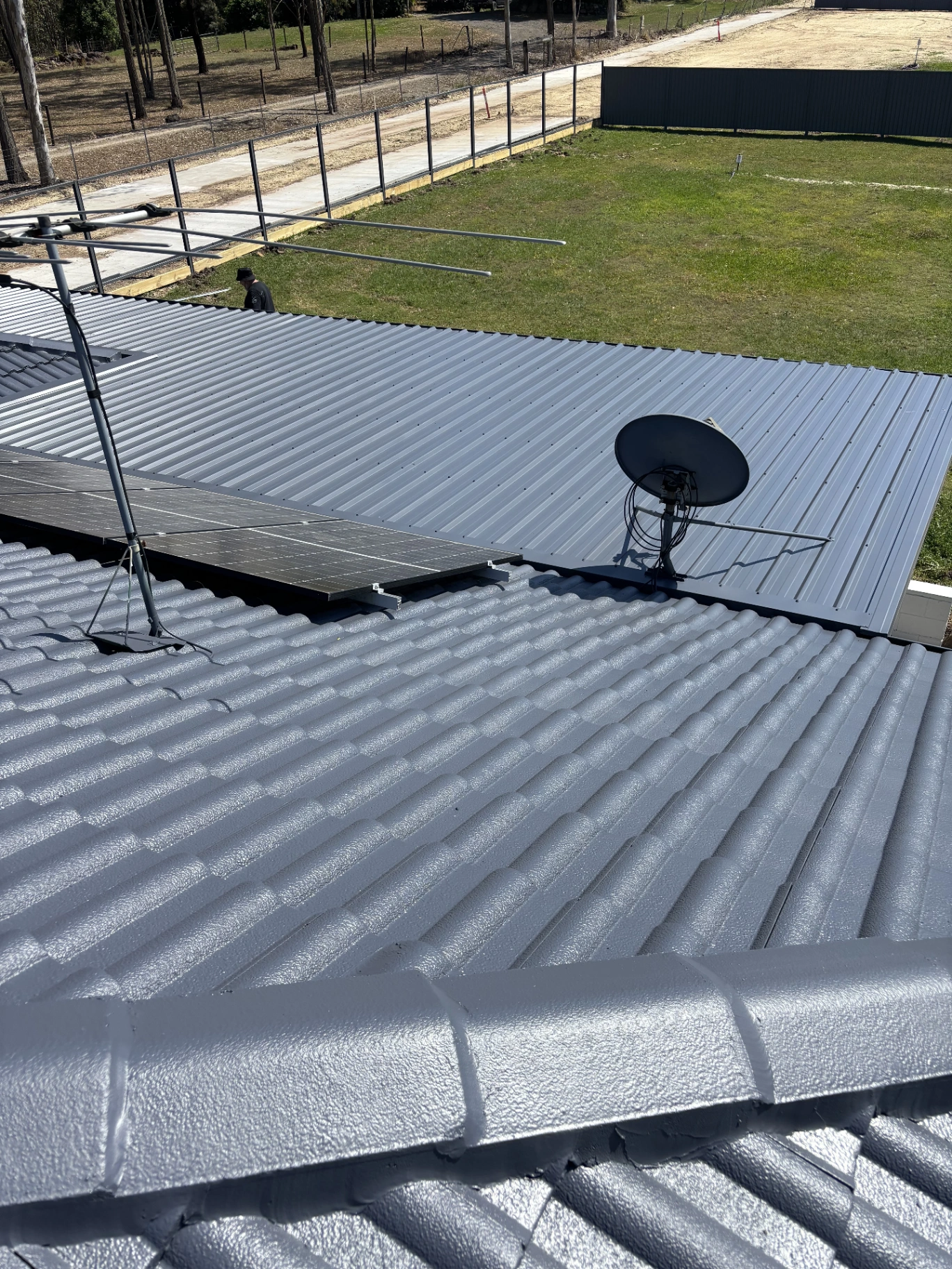 Freshly coated grey tiled and metal roof sections